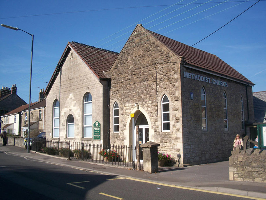 two two floor stone buildings with triangular roofs by a road