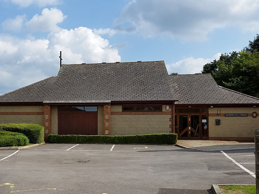 a sand coloured single floor building in a car park